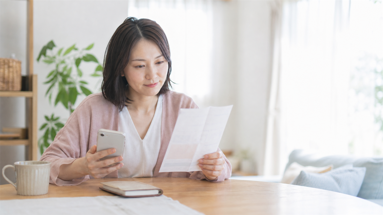 給料明細を見ながら、将来のお金について考える看護師の様子